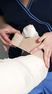 lymphedema therapist bandaging leg and foot